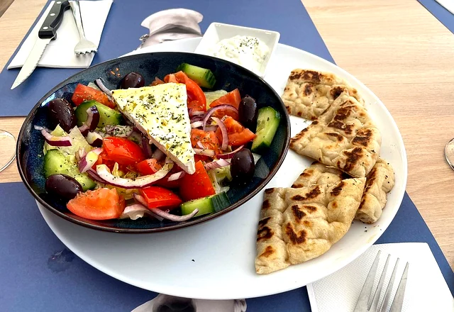 Ensalada griega con feta, tomate, pepino, olivas kalamata y pan de pita